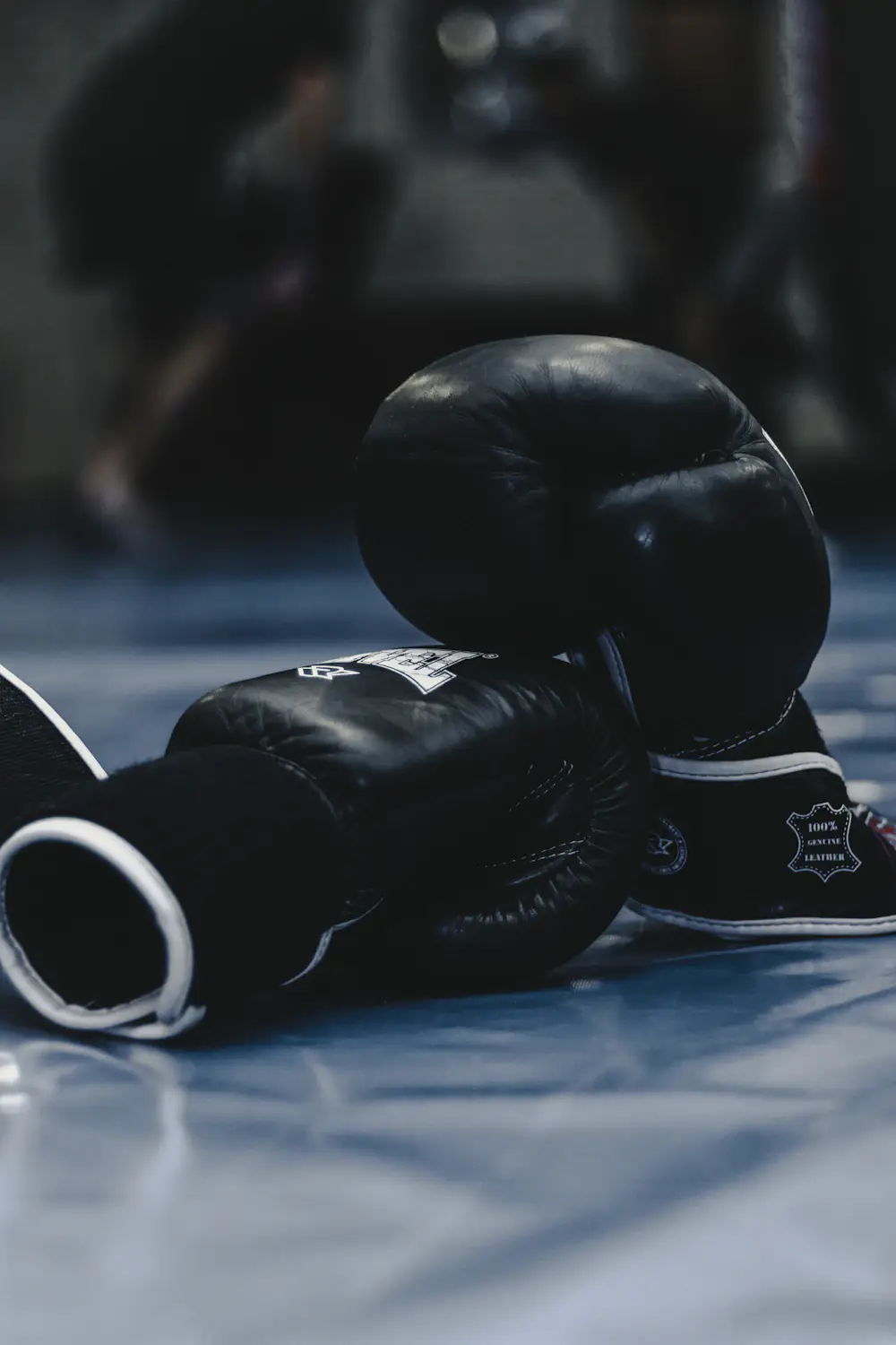 Black boxing gloves on the floor of a boxing gym