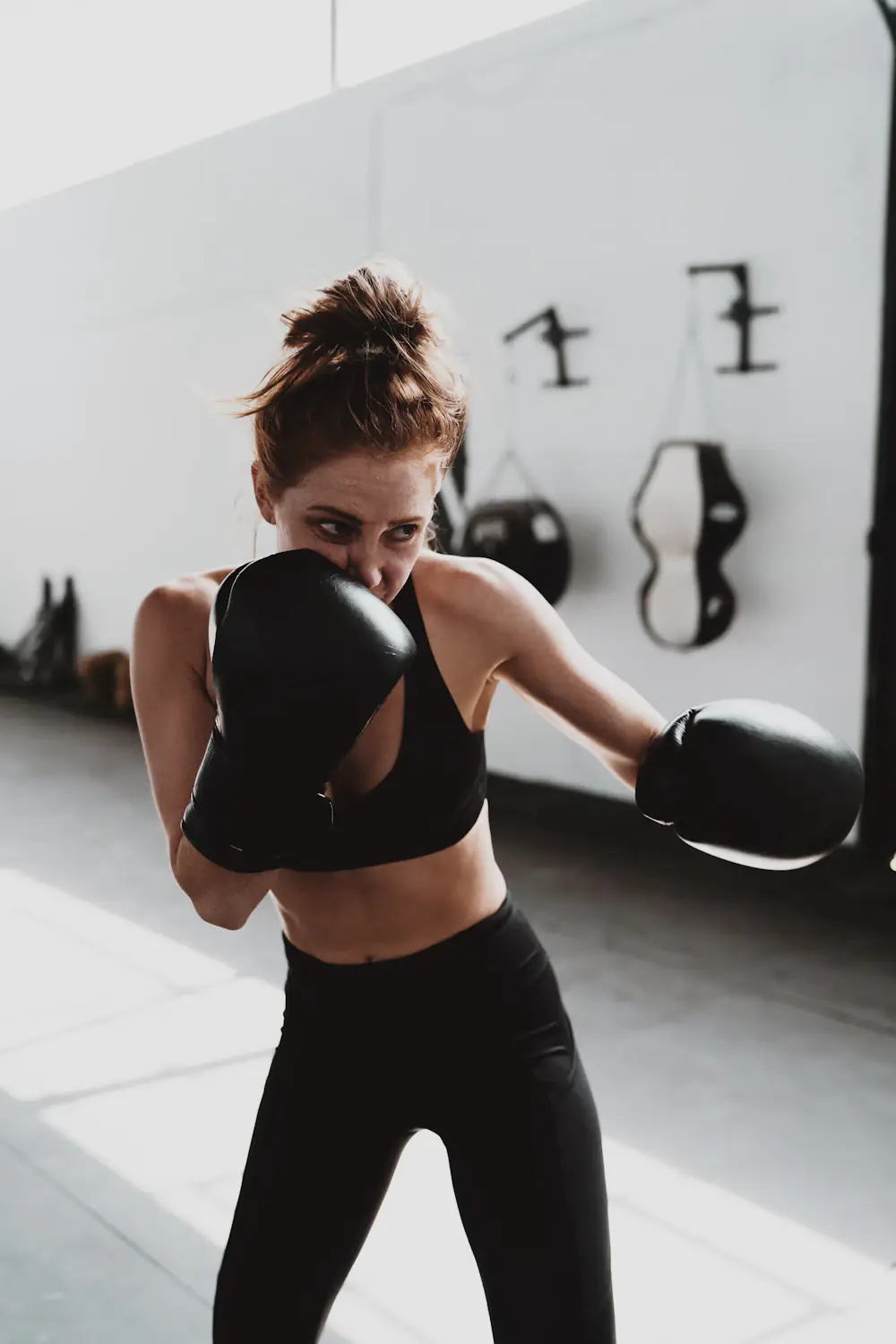 Woman practising boxing with one glove held in guard